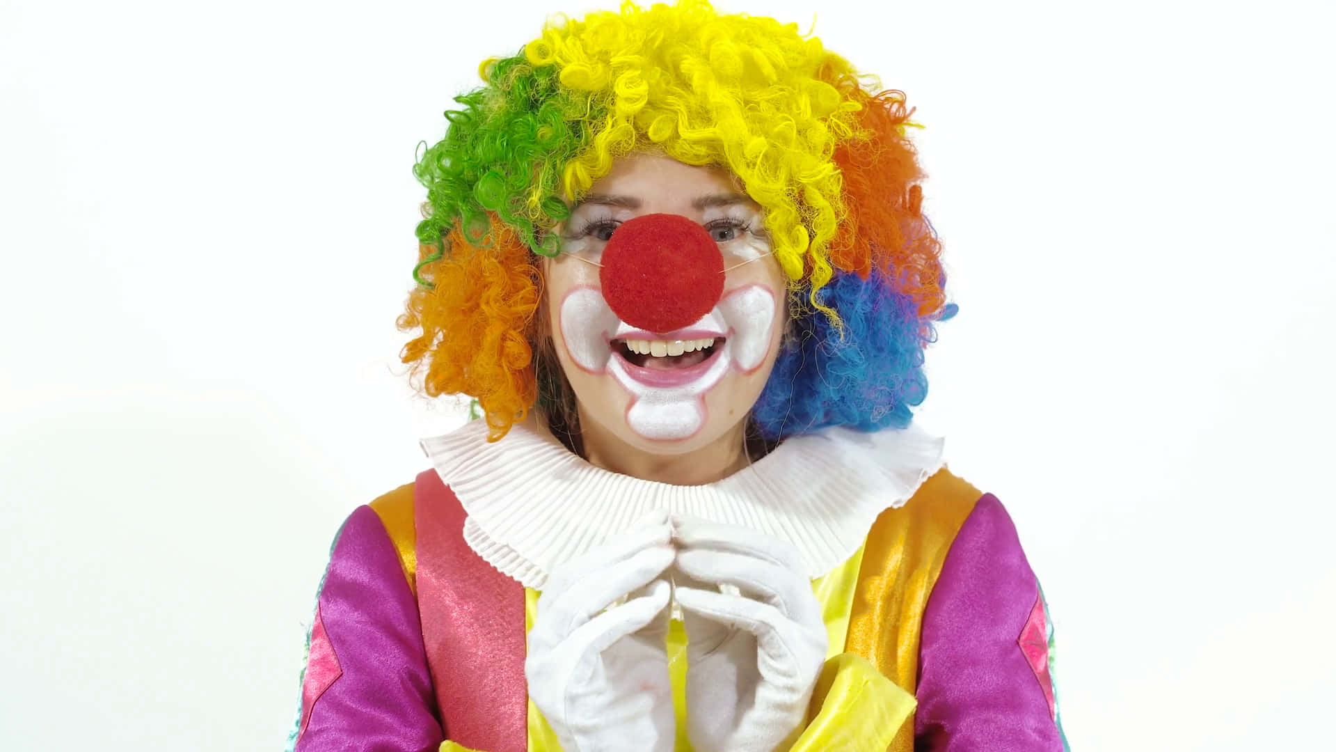 思考姿勢的搞笑小丑青少年 壁紙 — 一個戴著彩虹假髮和紅鼻子的快樂小丑，在純白背景上燦爛地微笑。