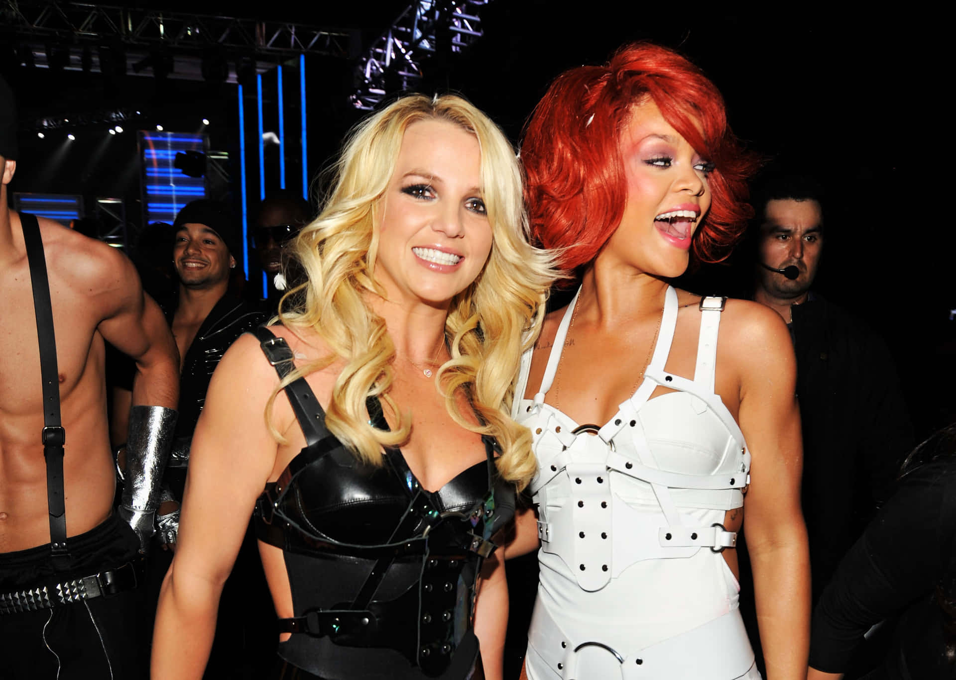 Britney Spears 和 Rihanna 在演唱會上穿著舞台服裝微笑。
