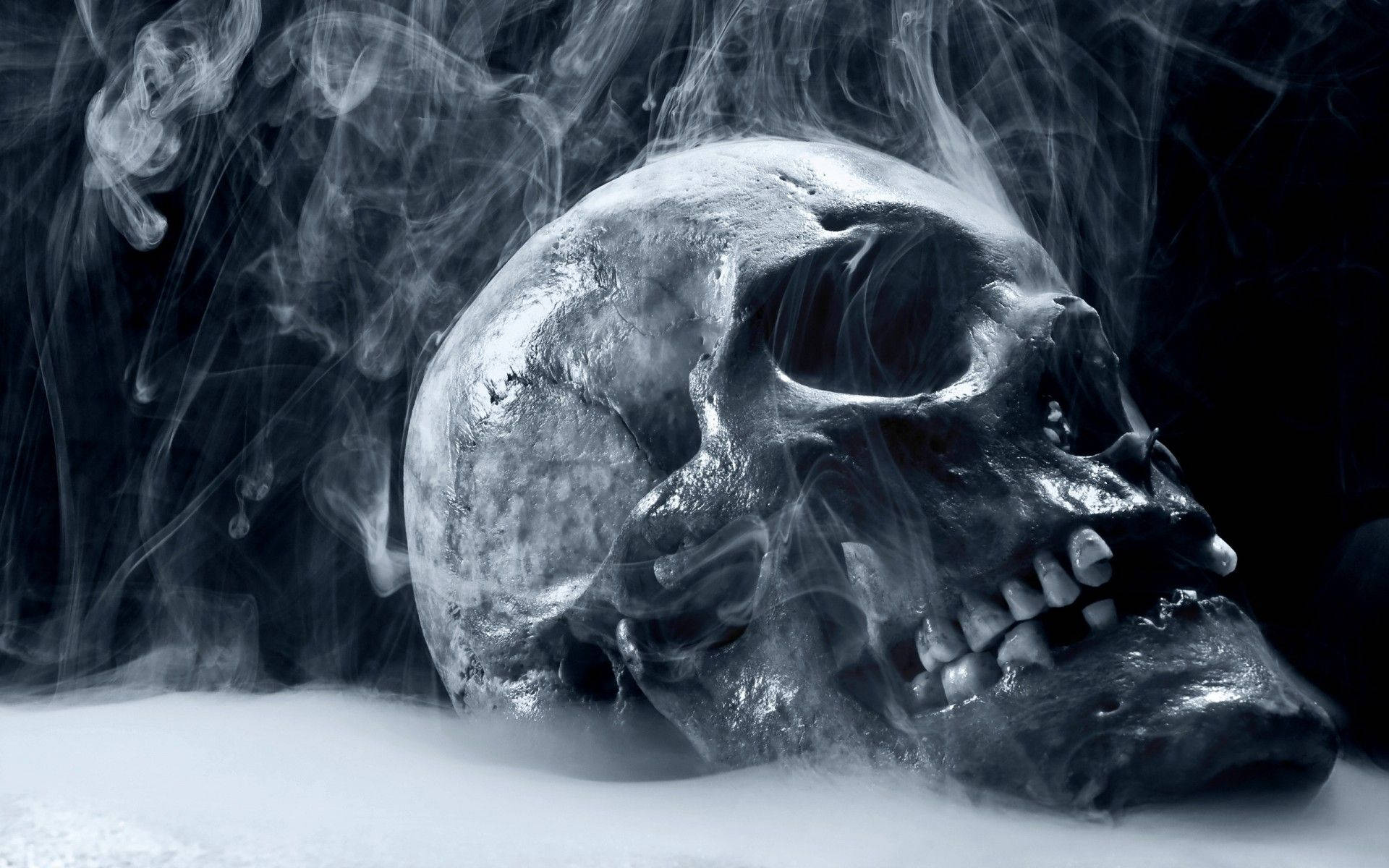 恐怖萬聖節煙霧骷髏 壁紙 — 一個令人毛骨悚然的人類頭骨從白霧中浮現，煙霧縈繞在空洞的眼窩和牙齒周圍。
