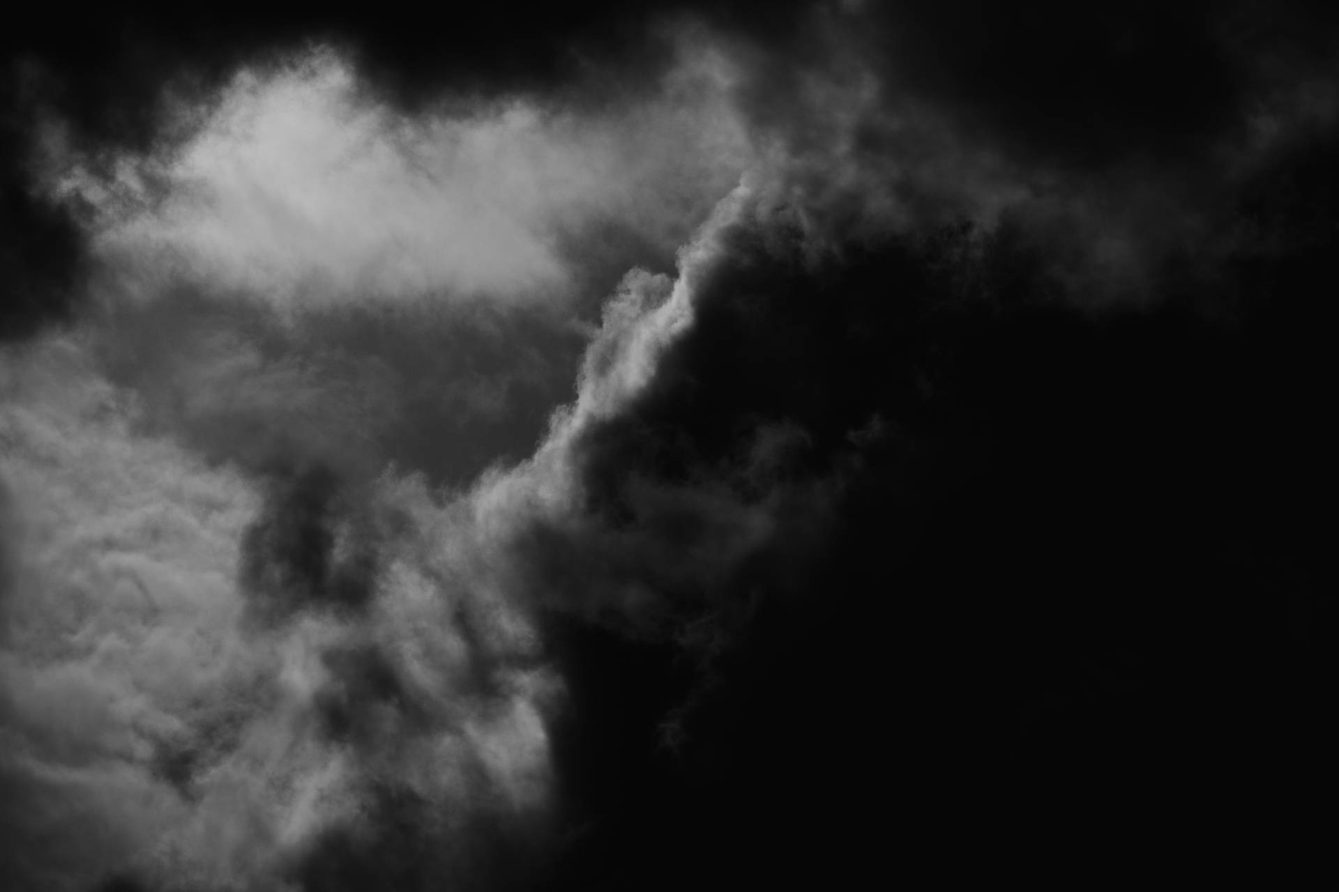 在黑暗天空襯托下的戲劇性單色旋轉雲朵