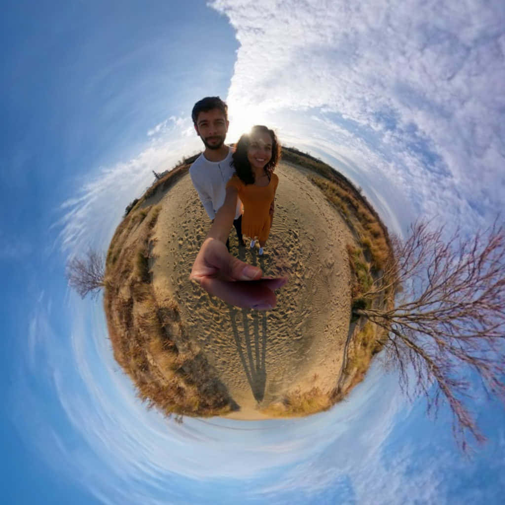 情侶藍天360度圖片 壁紙 — 一對微笑的情侶站在沙徑上，在明亮的藍天白雲下拍攝的360度魚眼自拍。