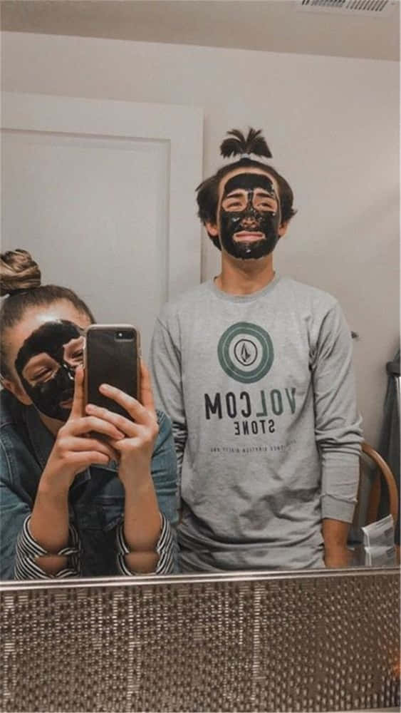 兩個人戴住黑色口罩喺浴室影鏡自拍。