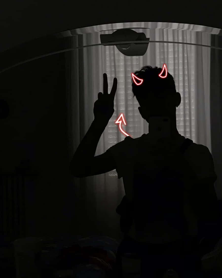 在黑暗房間中，帶有發光紅色惡魔角和和平手勢的剪影人物。