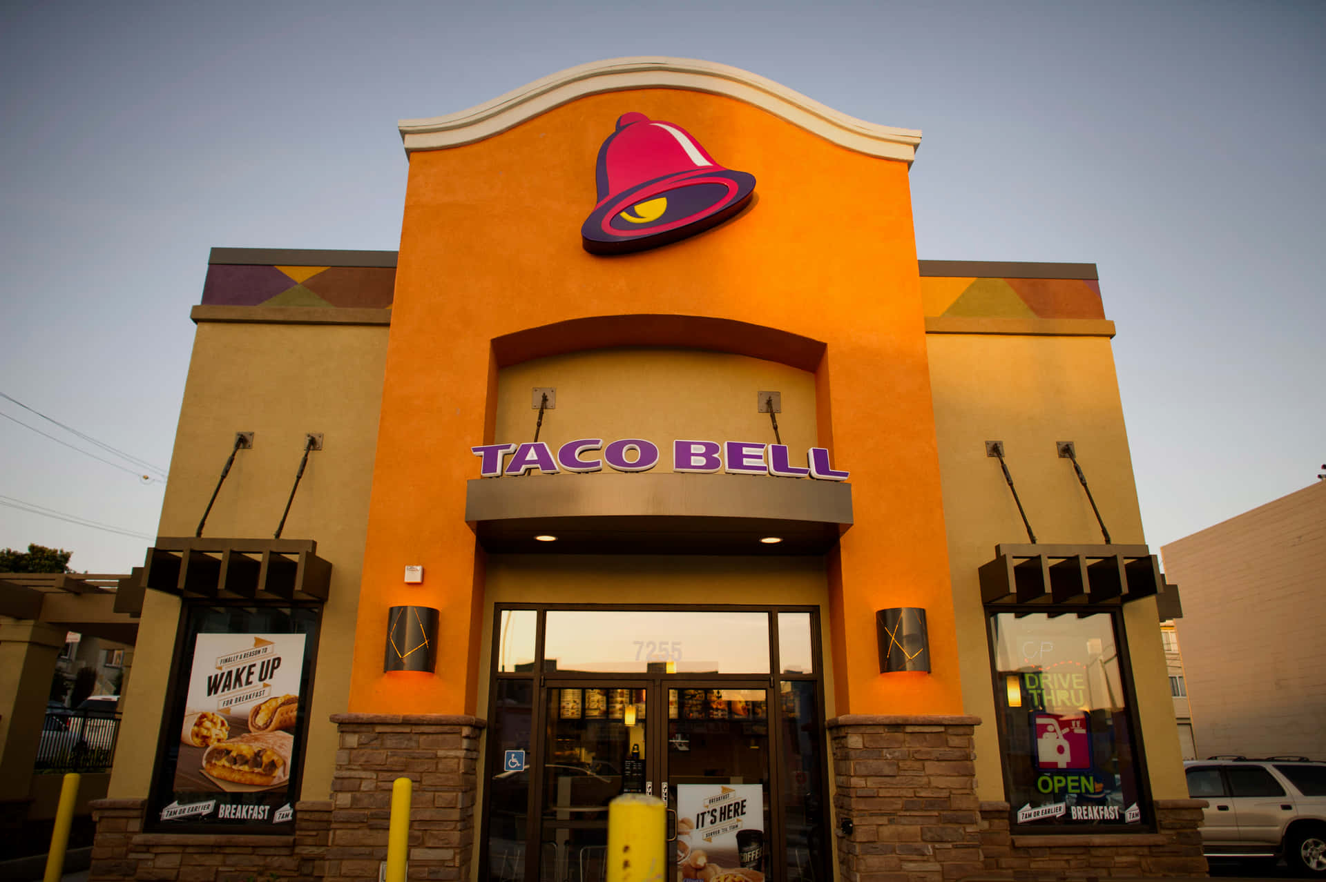 黃昏時分的Taco Bell餐廳外觀，設有發光招牌和得來速窗口。