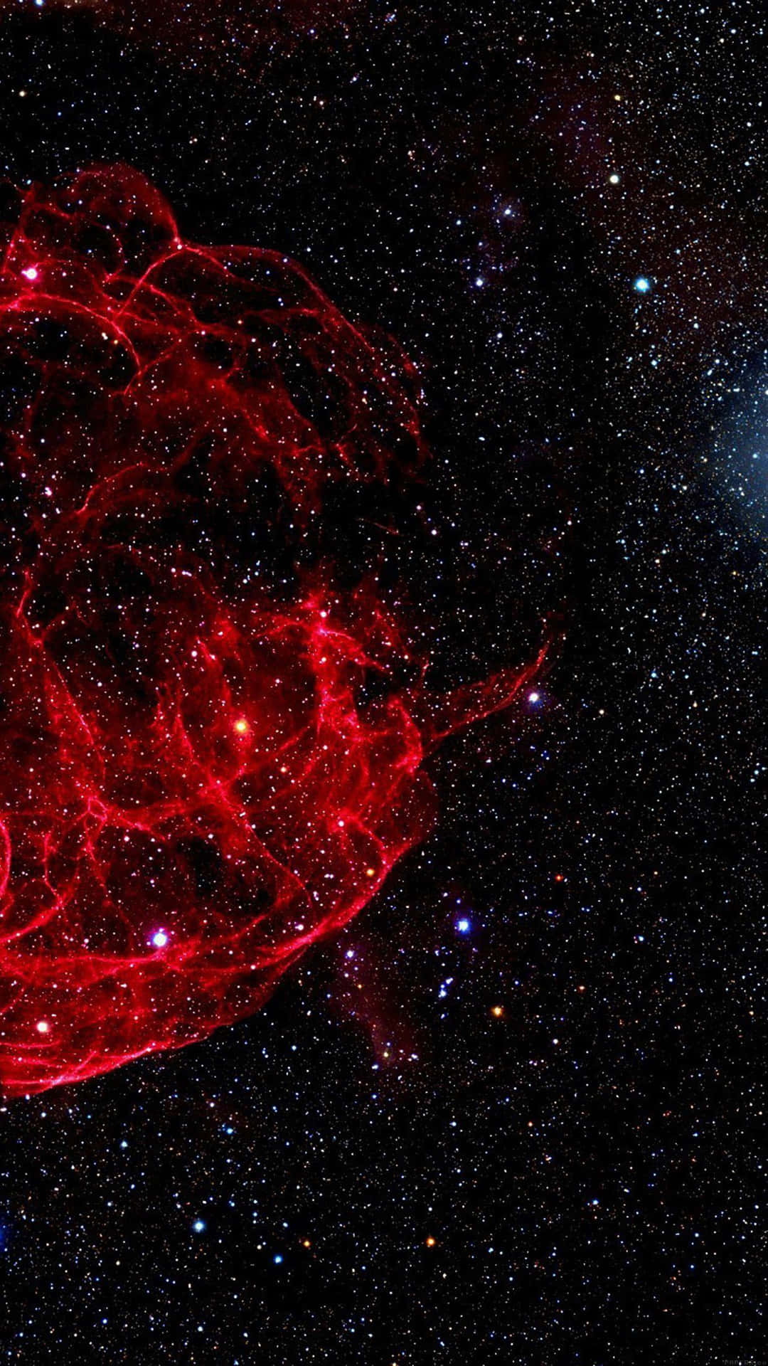 太空中一個發光的紅色星雲，周圍環繞著遙遠的星星。