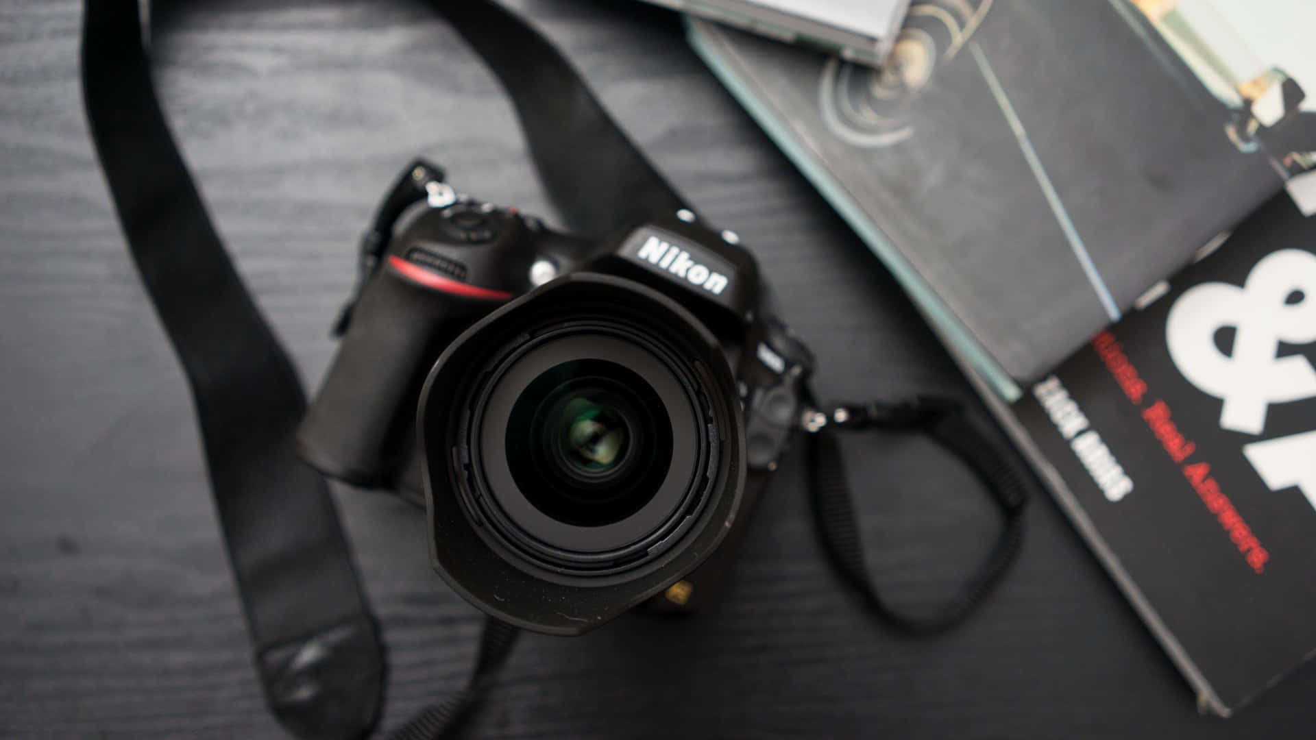 Nikon DSLR相機和攝影書籍在深色木質表面上