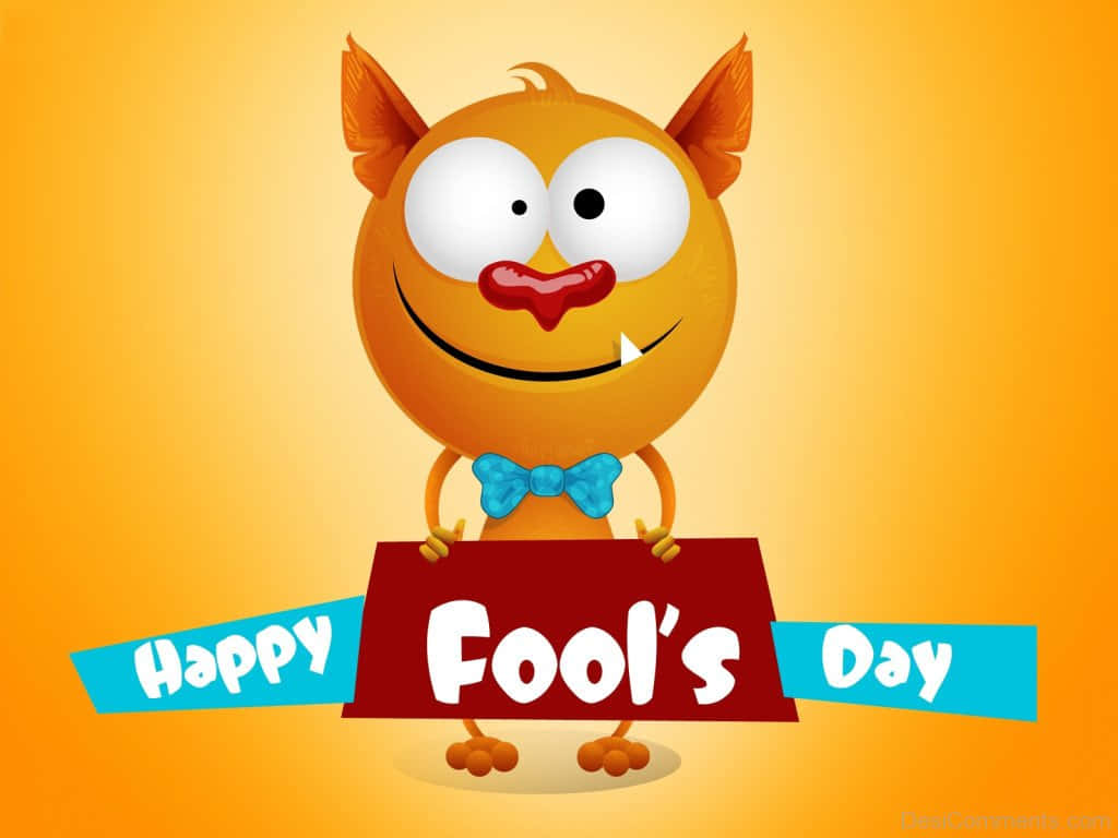 愚人節！ 壁紙 — 一隻開心嘅橙色卡通怪物，有大眼睛同蝴蝶結，喺溫暖嘅黃色背景上舉起一個紅色嘅牌，上面寫住 Happy Fool's Day。