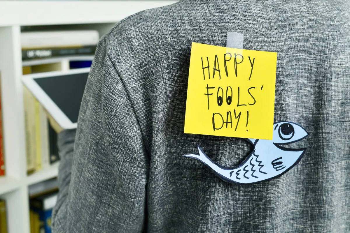 一張黃色便利貼寫著「HAPPY FOOLS' DAY!」，貼在灰色外套上，並有一個紙魚。