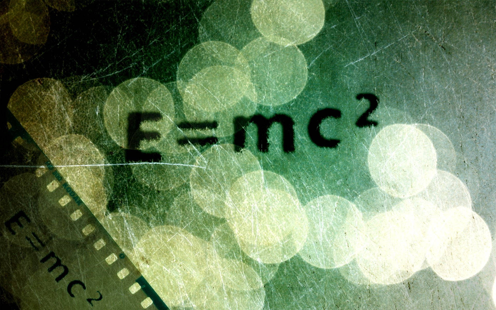 菲林條顯示E=mc²公式，帶有綠色散景燈光同刮痕。