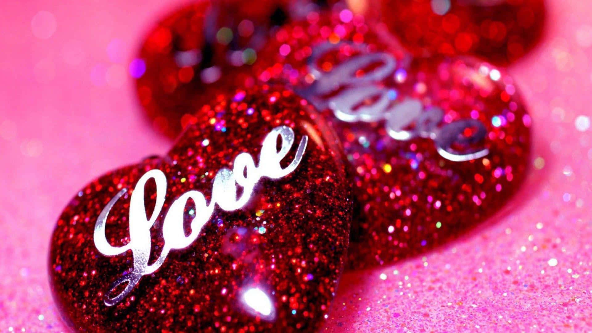 紅色閃粉心形配上銀色 love 文字，背景為粉紅色閃爍表面