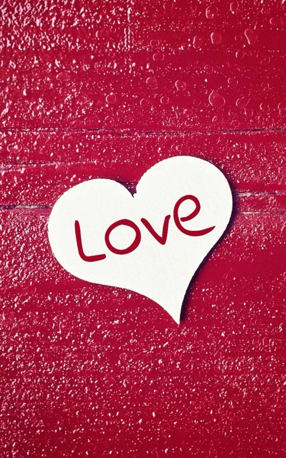 白色心心剪紙，紅色 'Love' 文字，放在帶水滴的紅色紋理背景上。