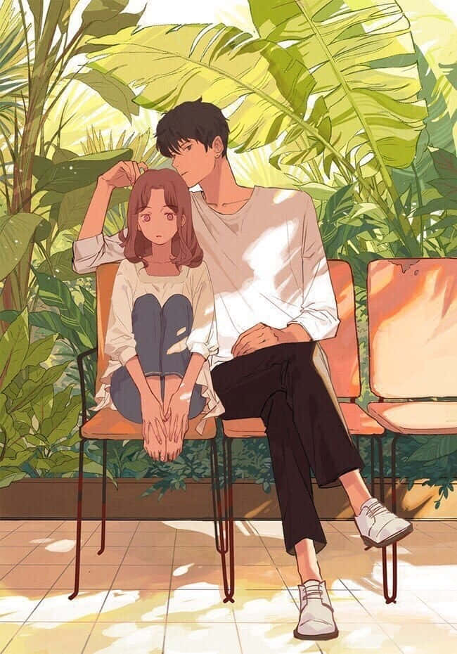一對年輕情侶在熱帶花園中一起坐在椅子上。
