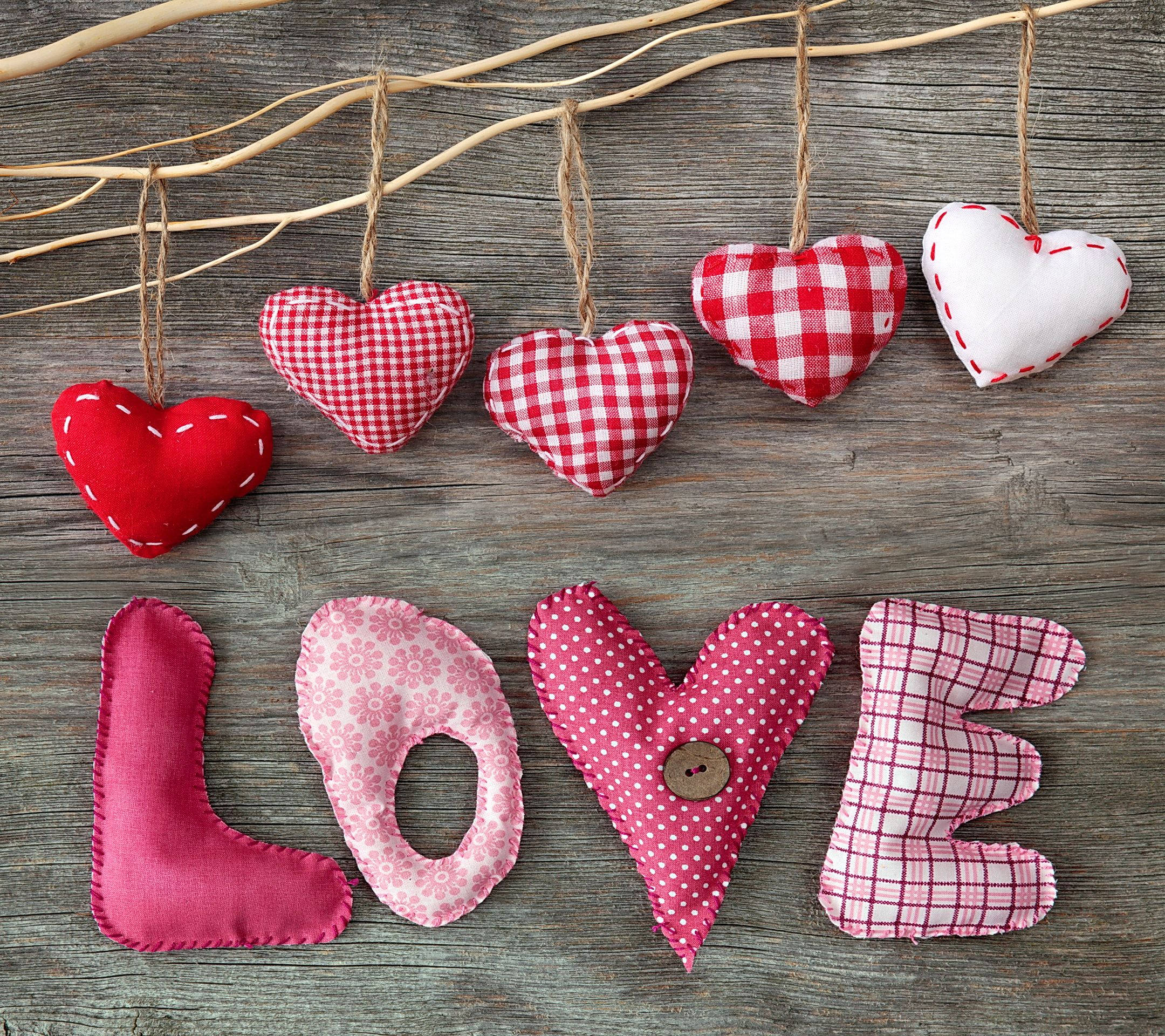 愛心美學 壁紙 — 手工布藝心形和拼布字母 LOVE 掛在麻繩上，背景是質樸的木頭。