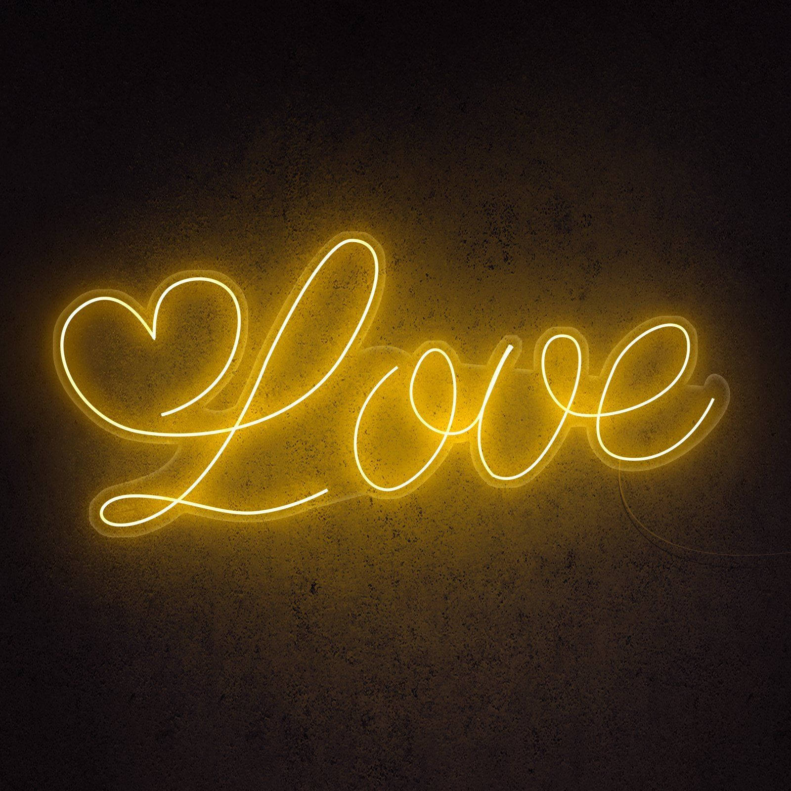 愛心霓虹黃LED燈 壁紙 — 一個發光的黃色霓虹燈牌，拼出 'Love'，其中 'L' 被心形取代，背景是深色紋理牆壁。