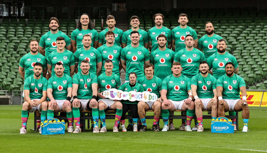 Ireland Rugby 桌布 壁紙 — 愛爾蘭欖球隊身穿綠色球衣在球場草地上擺姿勢，身後是空蕩蕩的綠色座位。