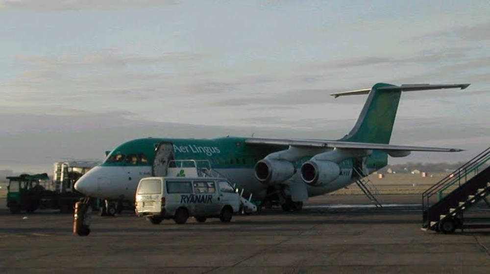 愛爾蘭航空飛機停在機場停機坪上，附近有瑞安航空貨車。