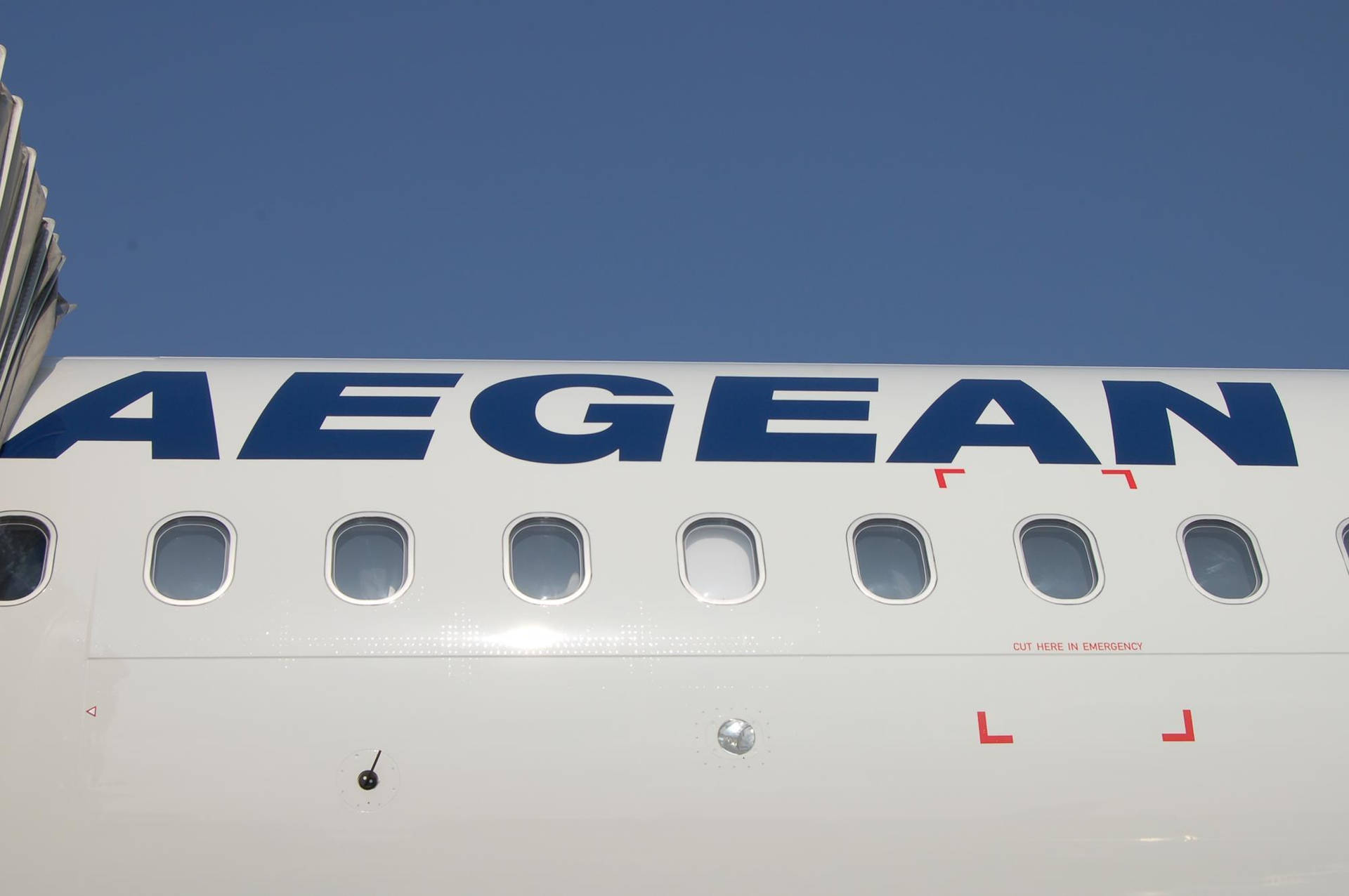 愛琴海航空飛機機身，在藍天下帶有乘客窗戶和緊急出口標記。
