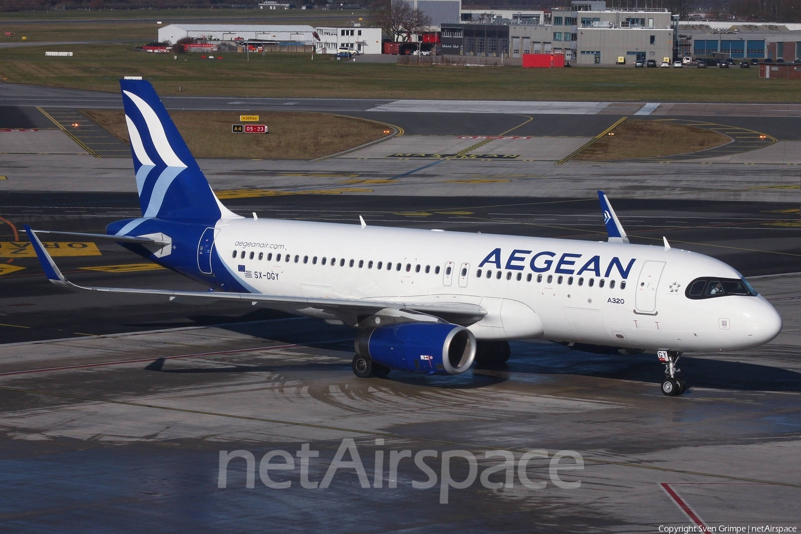 愛琴海航空空中巴士A320在濕滑的機場停機坪上