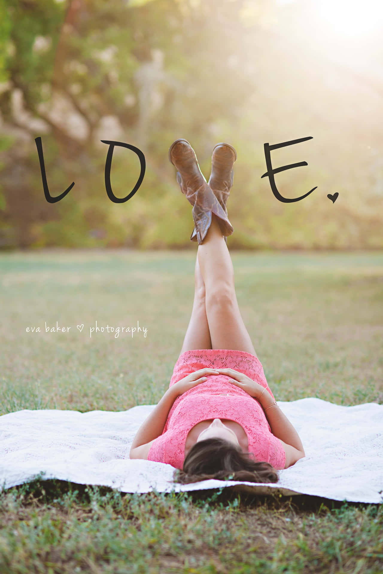 一位身穿粉紅色連衣裙和靴子的女性躺在草地上，頭頂有「LOVE」文字。