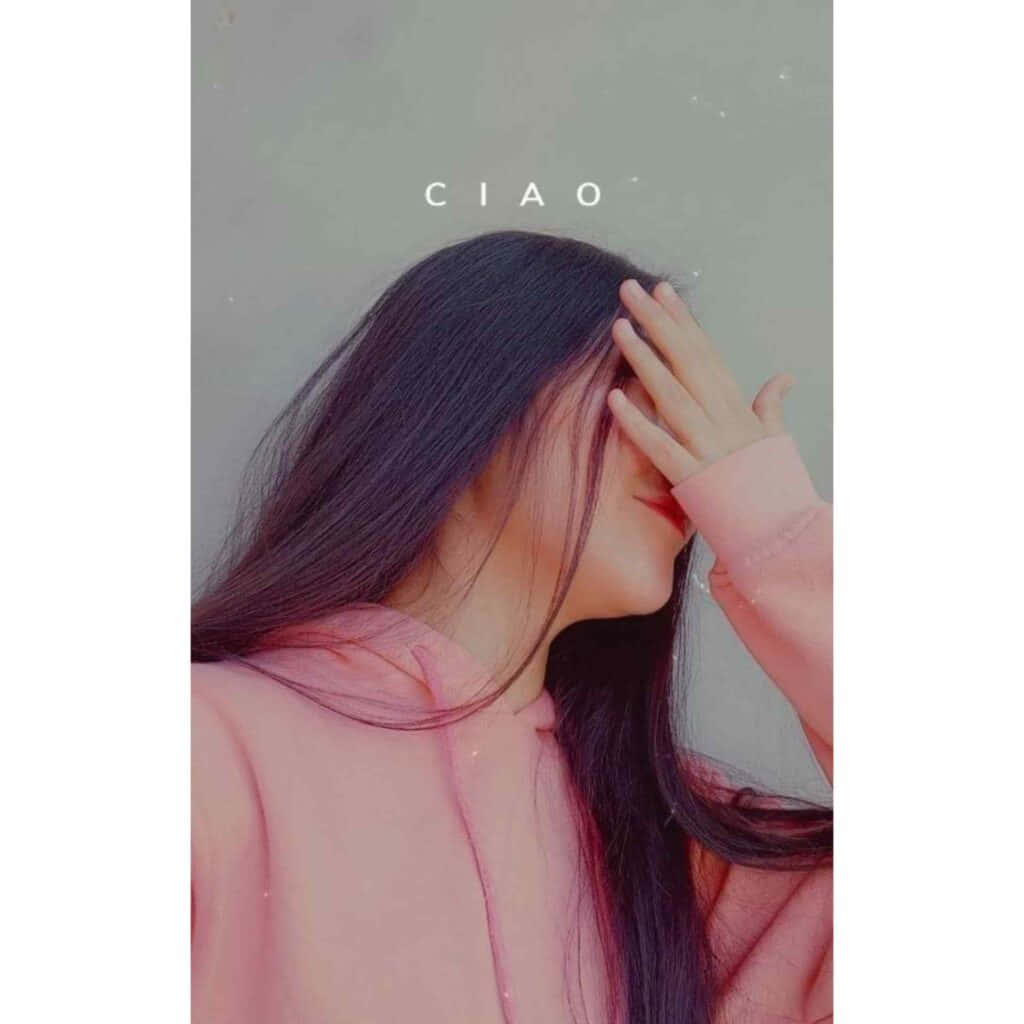 愛的生活 壁紙 — 一位長黑髮、身穿粉紅色連帽衫的年輕女子，在柔和的灰色背景前，輕輕用手遮住眼睛。