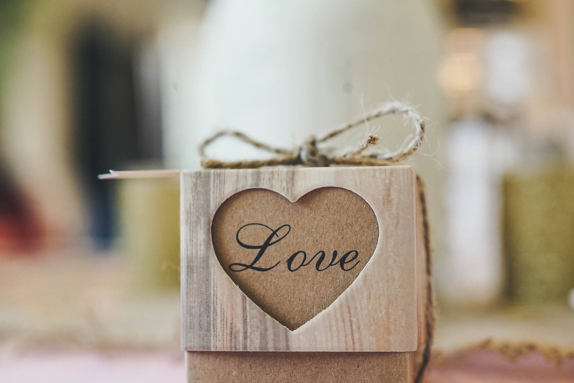 一個木盒，心形鏤空顯示「Love」字樣，用麻繩繫著。
