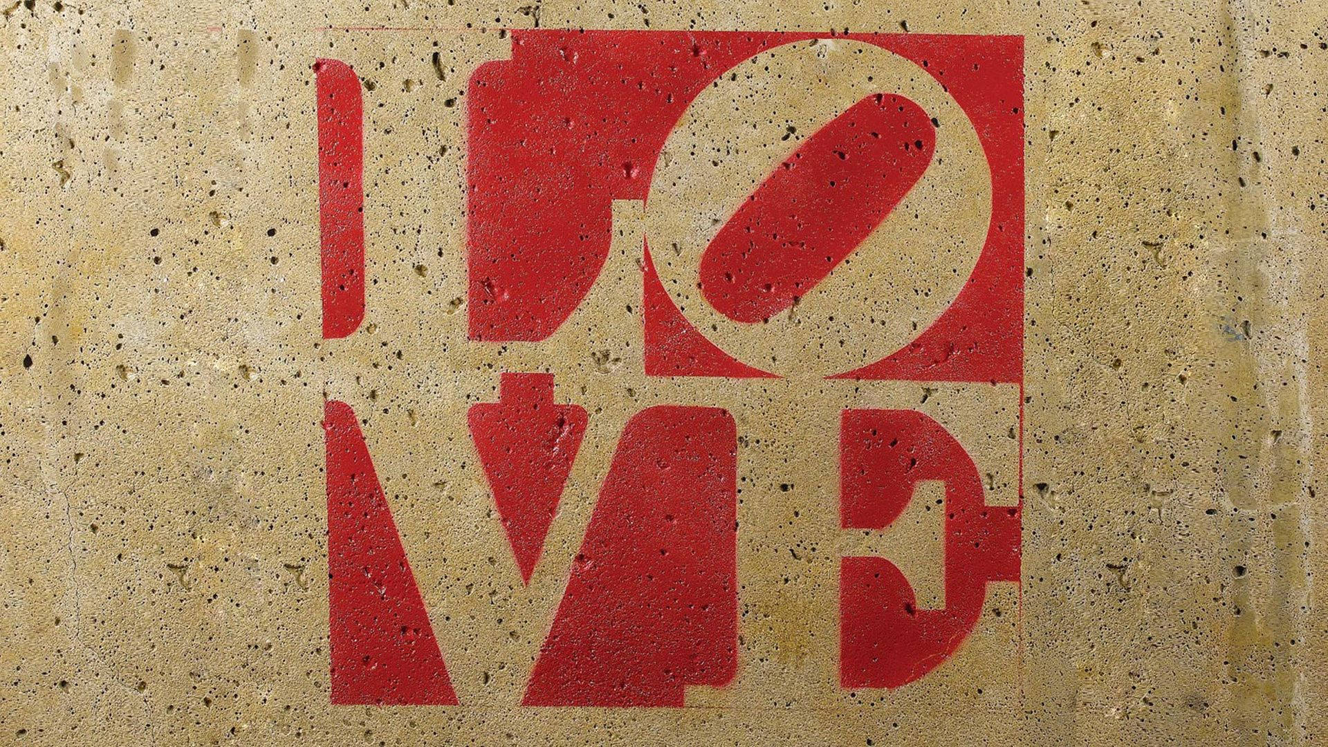紅色模板塗鴉在紋理混凝土牆上拼出 LOVE。