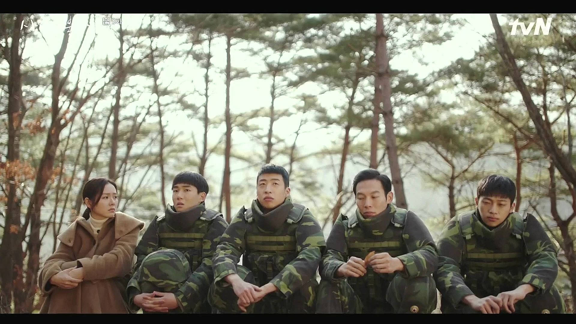 《愛的迫降》士兵與世莉 壁紙 — 五人身穿迷彩裝備，一人身穿棕色外套，在黃金時段的松樹林中莊嚴地坐著。