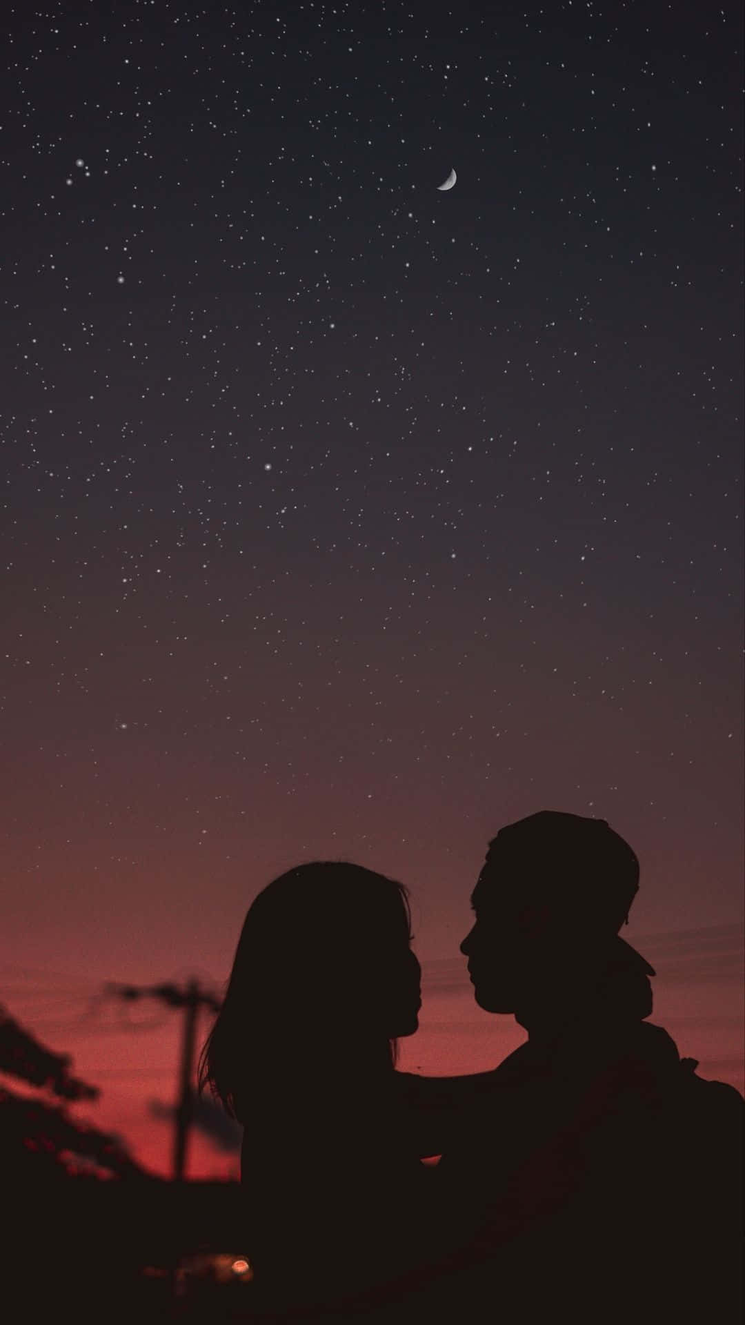 剪影情侶在繁星夜空下分享親密時刻。