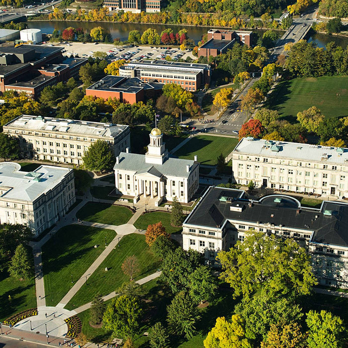 日落時分，大學校園的鳥瞰圖，有秋樹和古典建築。