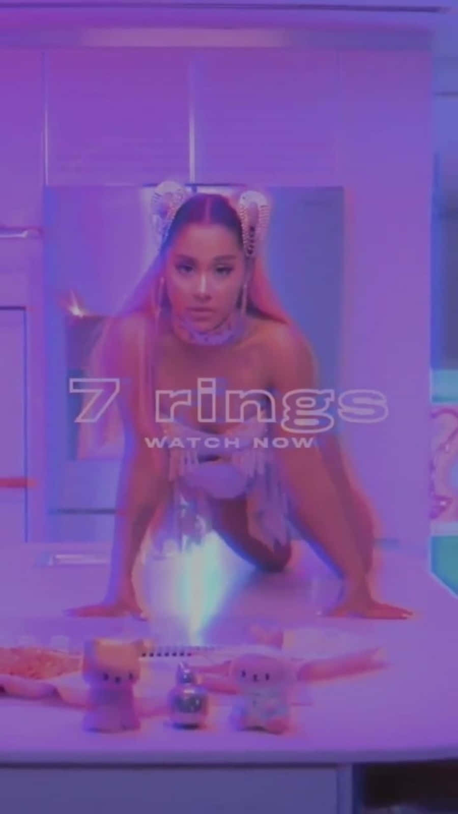 Ariana Grande 在一個紫色燈光的未來風格房間中，與毛絨玩具和發光戒指一起。