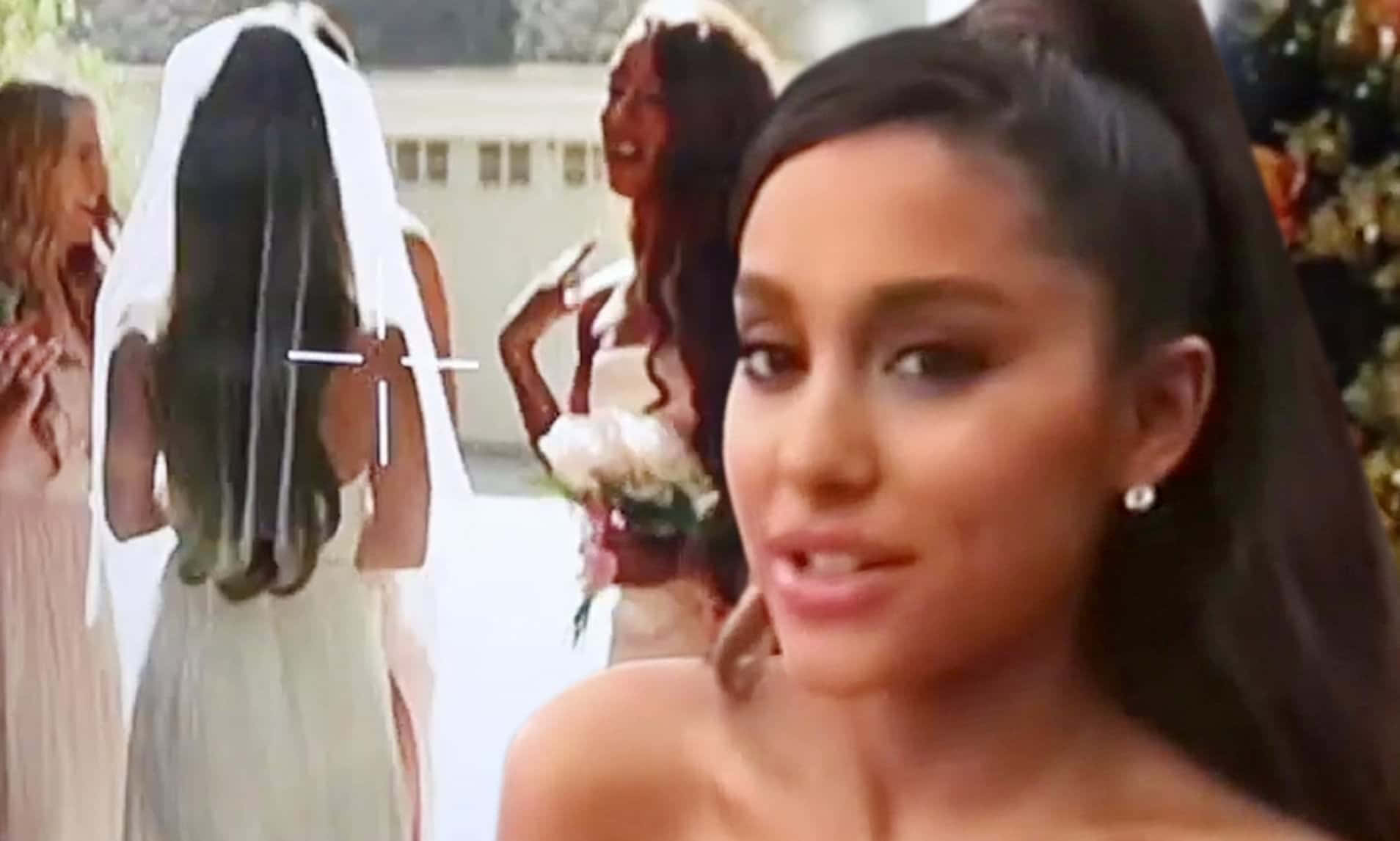 Ariana Grande 在婚禮上對著鏡頭微笑，背景有伴娘。