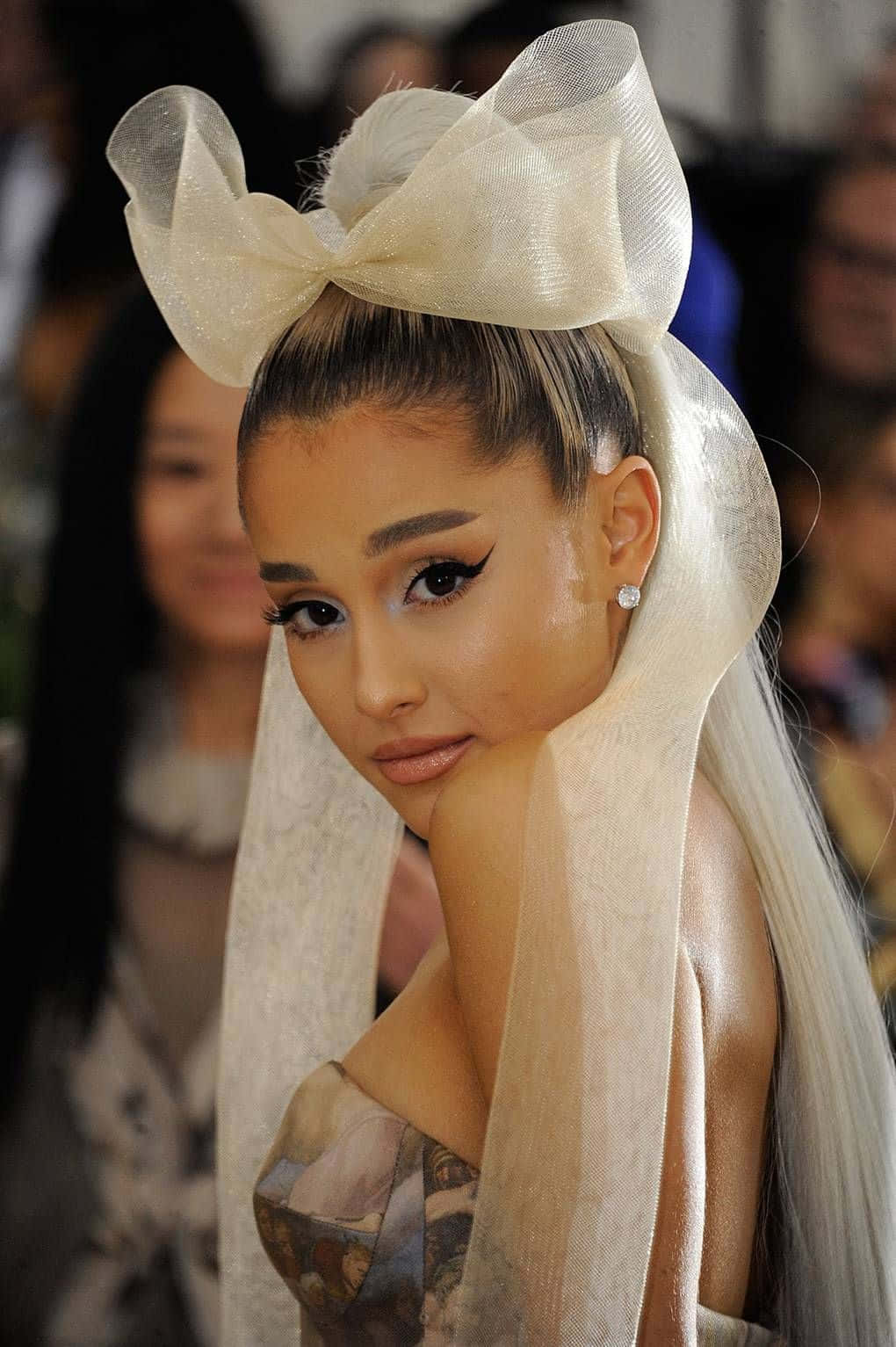 Ariana Grande 在時尚活動中戴著一個大奶油色蝴蝶結和面紗。