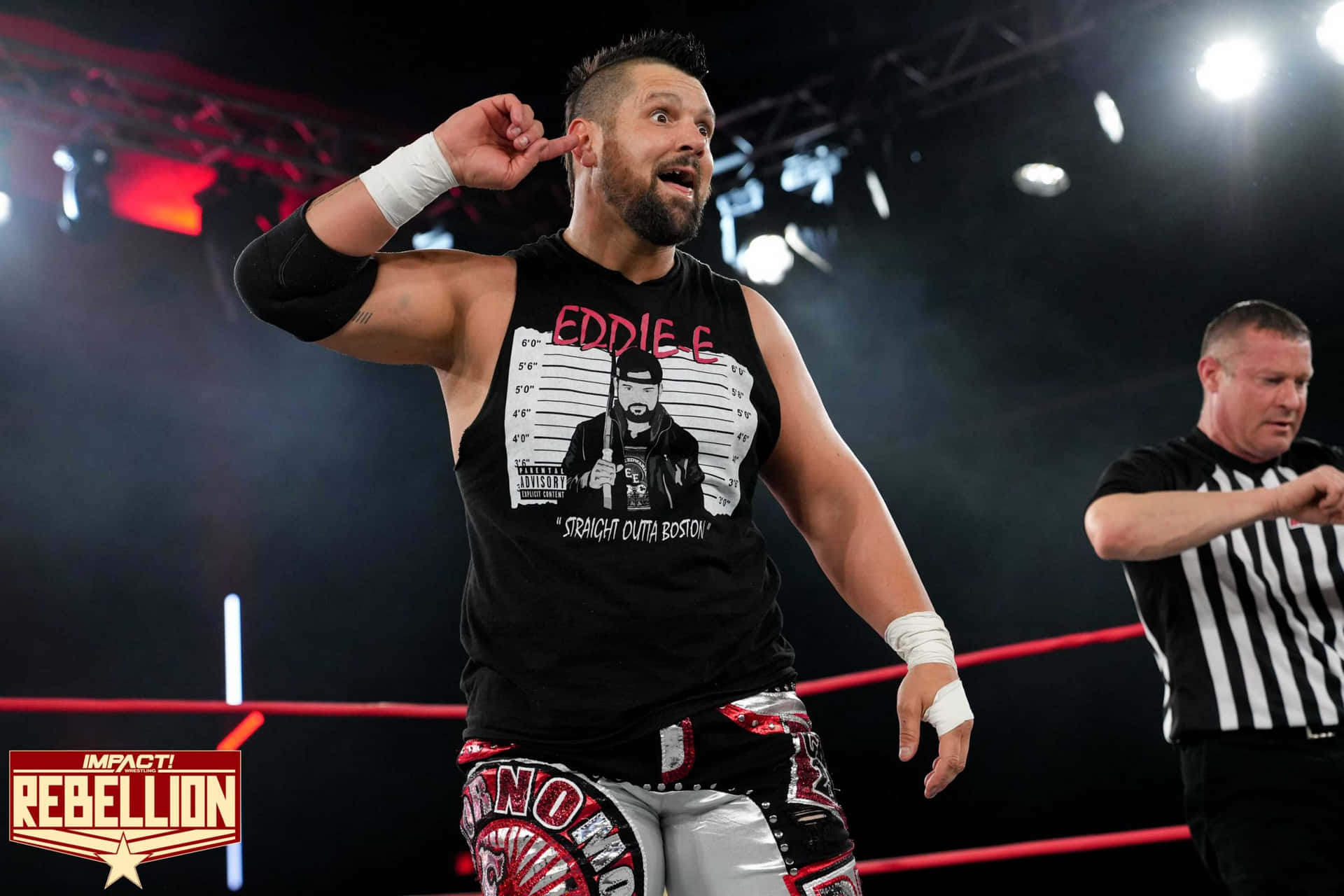 摔角手 Eddie Edwards 在 Impact Rebellion 活動期間與裁判在擂台上。