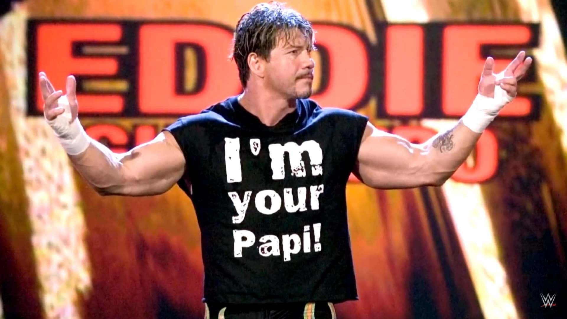 摔角手 Eddie Guerrero 穿著黑色 'I'm your Papi!' 襯衫在舞台上。
