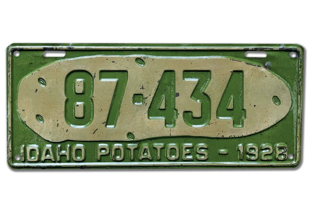 愛達荷州綠色馬鈴薯主題車牌 壁紙 — 1928年愛達荷州馬鈴薯車牌，帶有綠色銅鏽和編號87-434，顯示磨損痕跡。