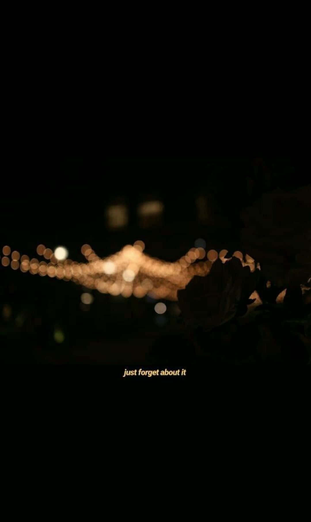 溫暖的散景燈光，帶有文字 just forget about it，背景為深色。