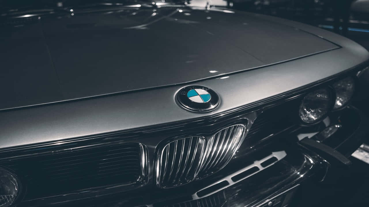 感受 BMW 的力量與奢華 壁紙 — 經典寶馬汽車引擎蓋和標誌性雙腎型進氣格柵的特寫，在氣氛燈光下。