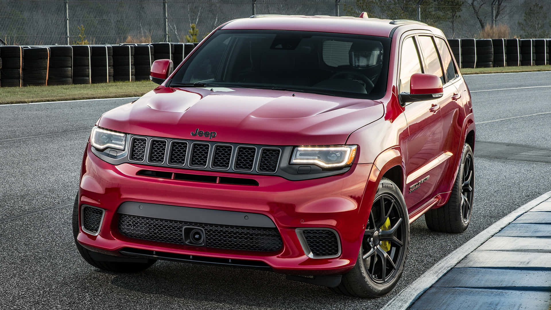 賽道上的紅色Jeep Grand Cherokee Trackhawk，黑色車輪和黃色制動卡鉗。