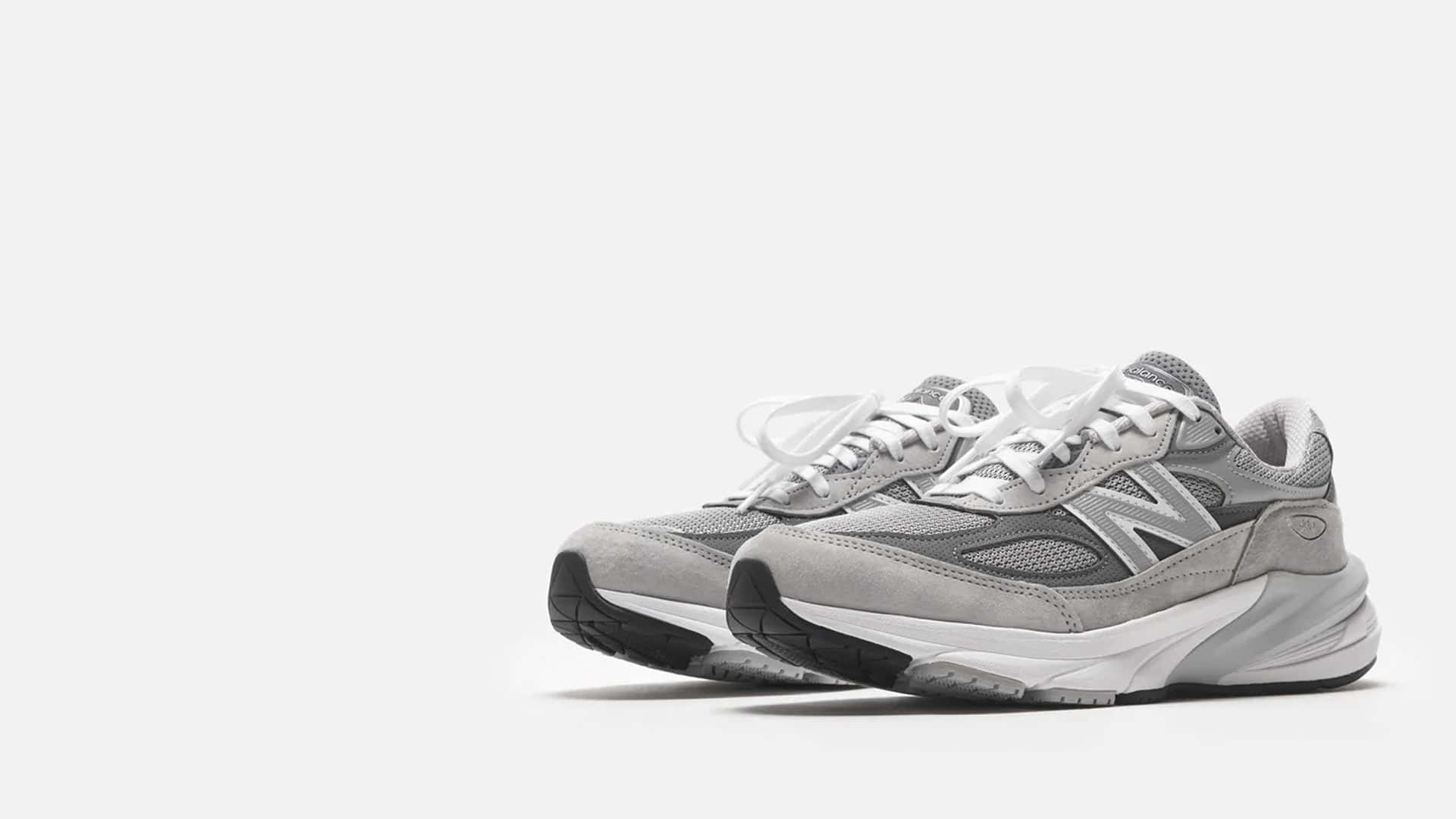 純白色背景上的灰色 New Balance 運動鞋，配有白色鞋帶和厚鞋底。