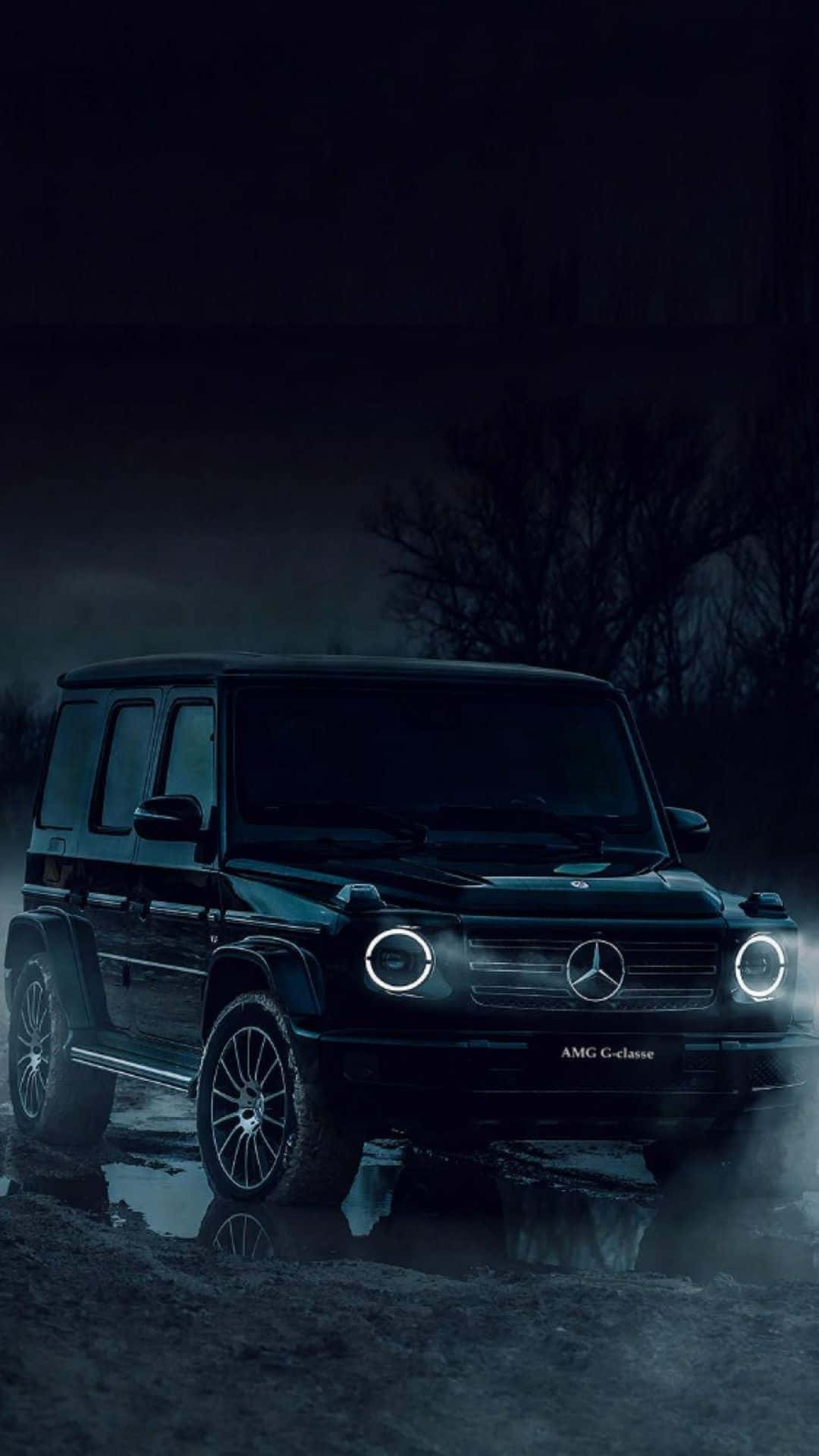 夜晚黑暗霧氣森林中，一輛黑色梅賽德斯G級SUV，車頭燈發光。