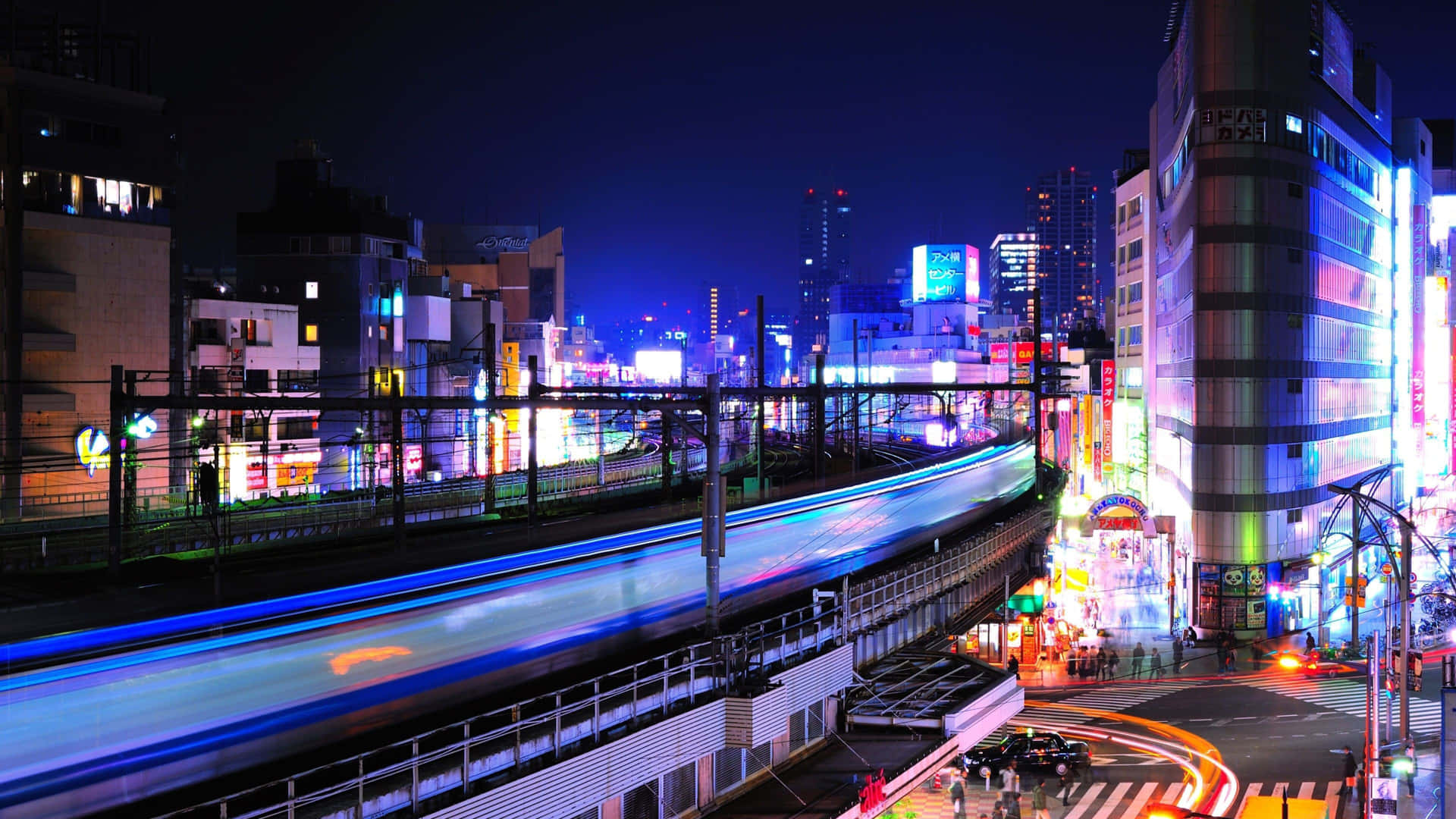 霓虹燈照亮都市夜景，火車光軌和發光廣告牌。