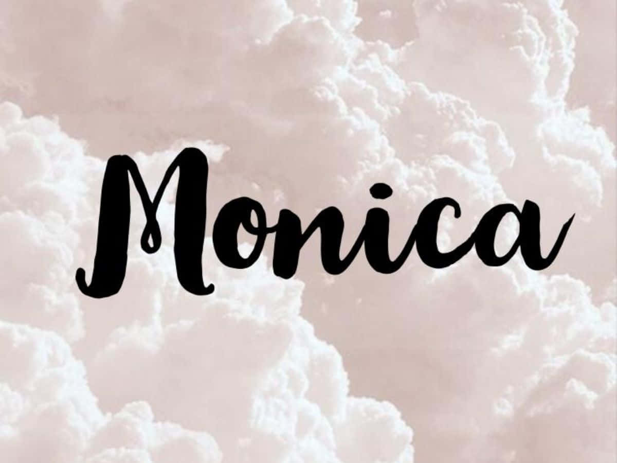 感受名字的力量 壁紙 — 名字 Monica 以優雅的黑色字體漂浮在柔和的粉紅色和白色 fluffy 雲背景上。