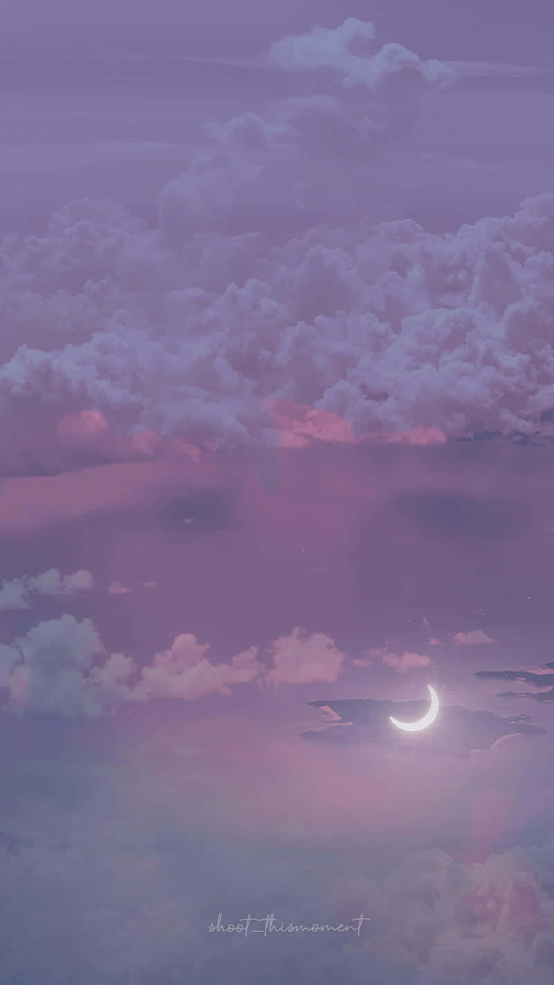 暮色中，彎月透過粉紫色雲朵閃耀。