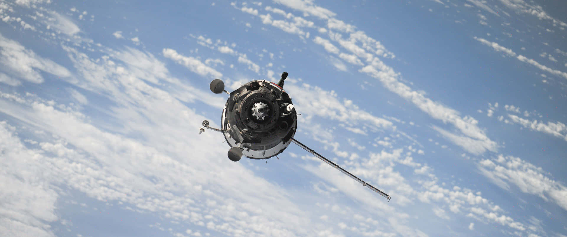 衛星在地球上空軌道運行，雲層覆蓋