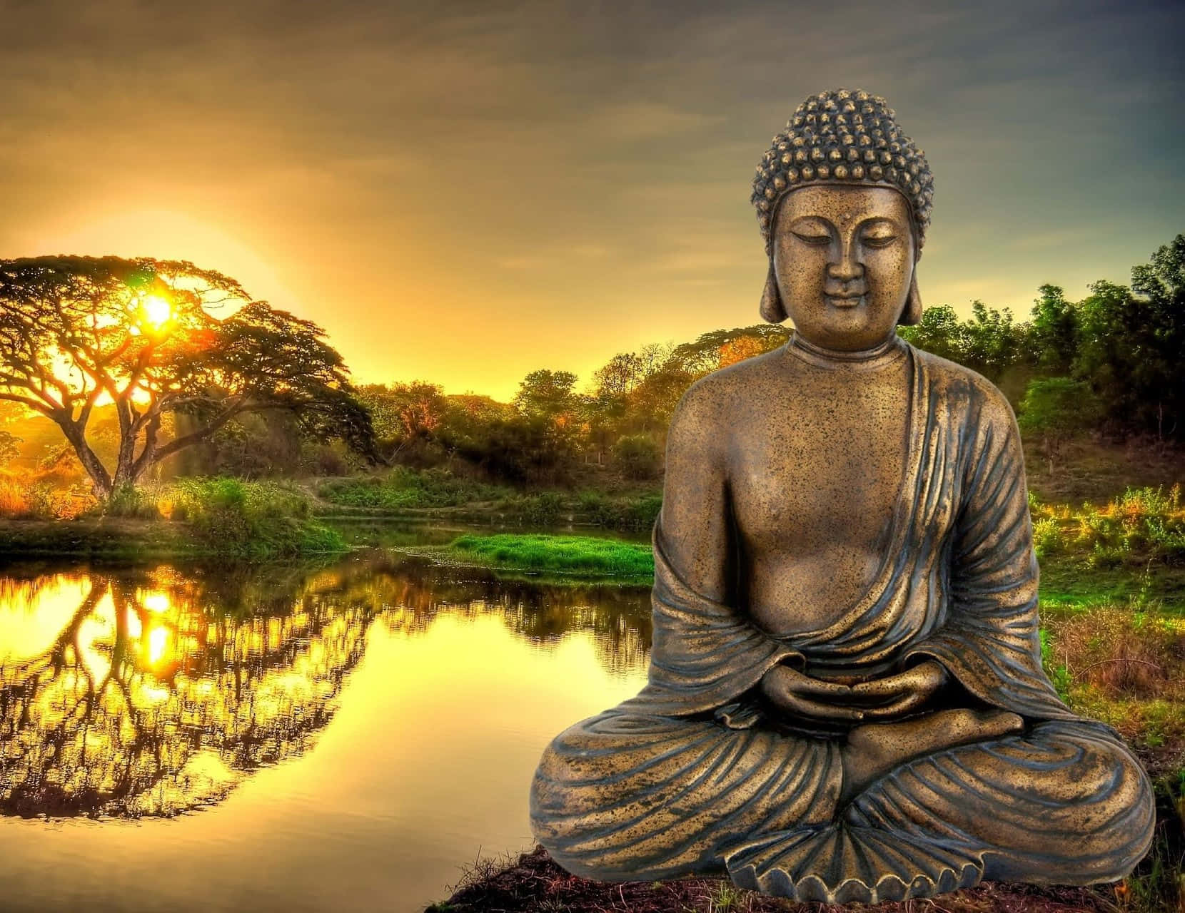 感受寧靜 壁紙 — 一尊寧靜的青銅佛像坐在寧靜的池塘邊，金色夕陽下，樹影在水中閃爍。