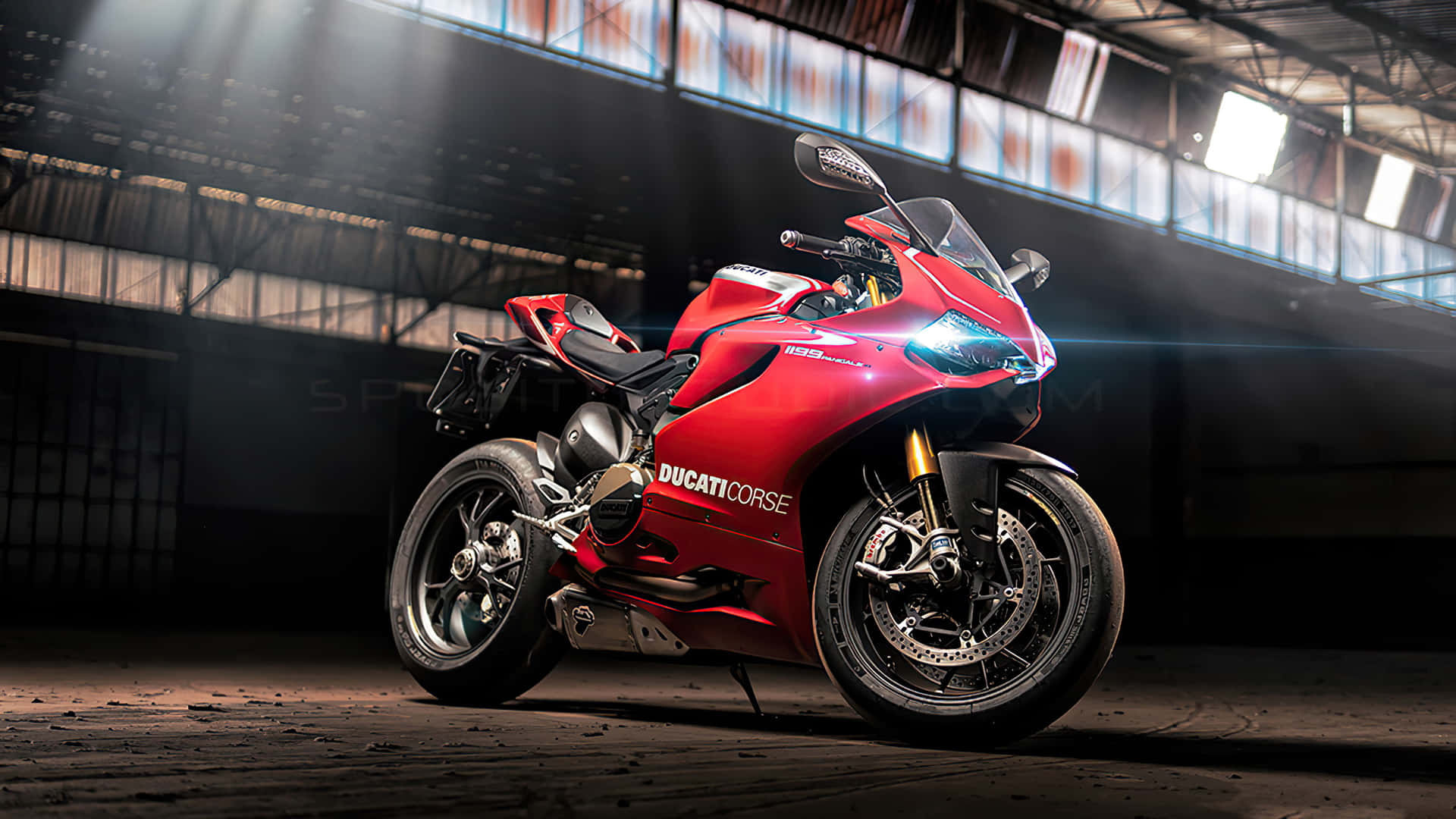 昏暗倉庫中帶有聚光燈光束的紅色Ducati電單車。