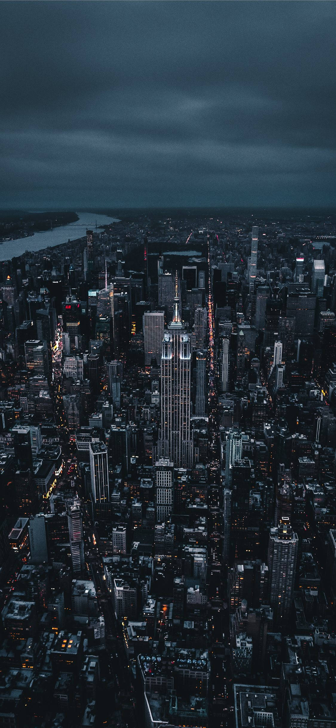 感受永不停歇的城市——紐約 壁紙 — 紐約市夜景鳥瞰圖，帝國大廈在黑暗多雲的天空中亮起。