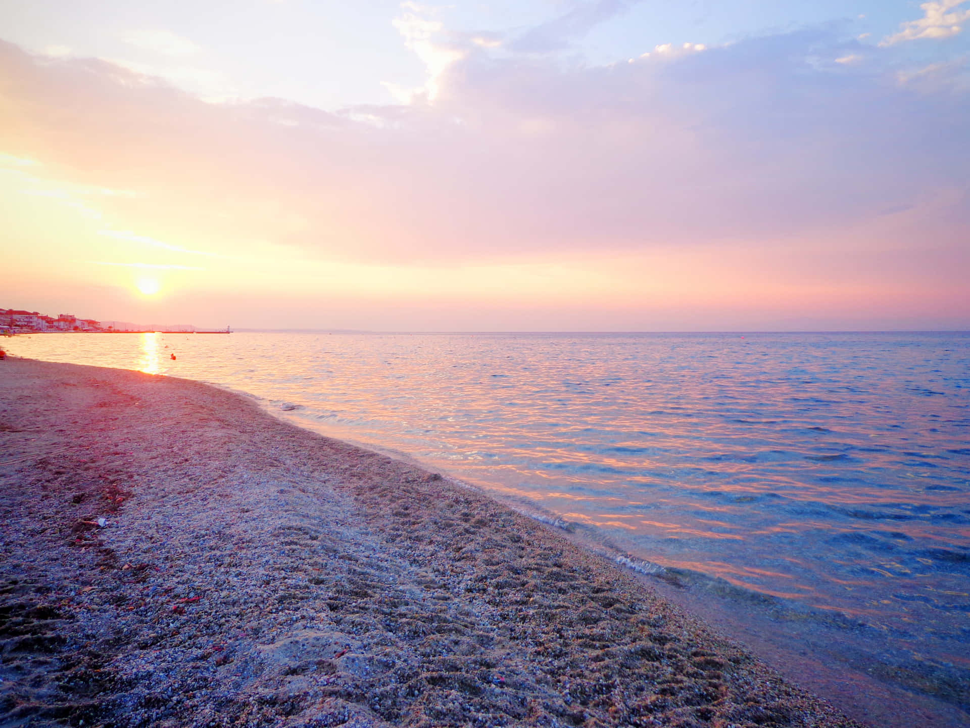 平靜海洋上的夕陽，前景是沙灘
