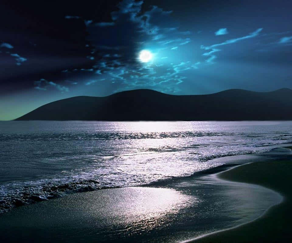 感受海灘夜晚的寧靜平和 壁紙 — 月光在寧靜的海洋上閃爍，波浪在黑暗多雲的天空下拍打著彎曲的海岸。