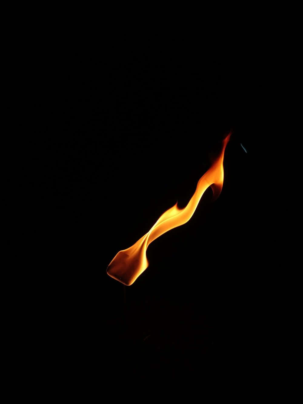 感受火焰無可抗拒的熱力 壁紙 — 一束鮮豔的橙色火焰在純黑色背景上優雅地舞動。